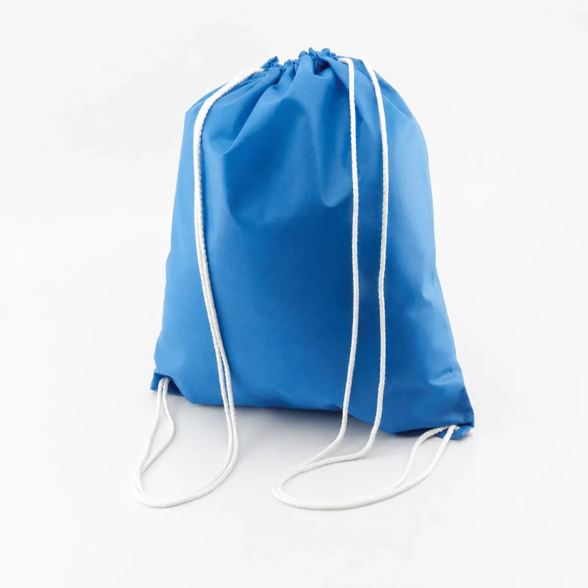 Morral ecológico grande azul con cordones blancos y ojillos metálicos sobre fondo gris claro