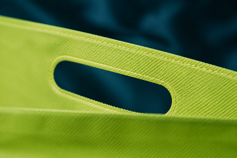 Detalle de asa troquelada en bolsa ecológica non woven verde lima